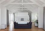 White vaulted wood beam ceiling over bed in home showcase interior