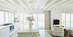 White kitchen with wood beam ceilings in home showcase interior