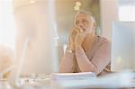 Focused businessman working at computer in sunny office