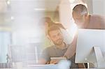 Businessmen with digital tablet talking in office