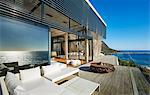 Modern luxury beach house patio with sunny ocean view