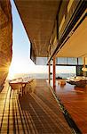 Dining table on modern luxury patio with sunset ocean view