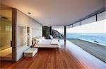 Modern luxury bedroom open to patio with ocean view