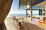 Modern luxury dining table on sunny patio with ocean view