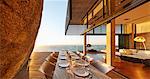 Modern luxury patio dining table with sunset ocean view