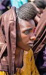 Niger, Agadez, Inebeizguine. A Wodaabe girl with traditional facial scarification watches a Gerewol ceremony performed by the young men of her tribe.