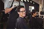 Hairdresser dyeing hair of her client at a salon