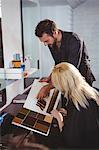 Woman selecting a hair color with stylist at the hair salon