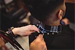 Female barber removing client apron in barber shop