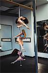 Pole dancers practicing pole dance in fitness studio