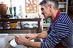 Male potter making pot in pottery workshop