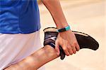 Young people doing sport activities, man runner jogging stretching leg using fit watch. Concept of leisure, health, recreation, fitness, lifestyle, exercising, workout