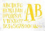 Font pencil vintage hand drawn alphabet drawing in yellow color on dirty paper background.