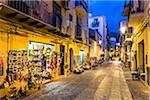 Shops along Narrow Street at Night in Cefalu, Sicily, Italy