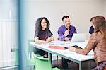 Designers having meeting at design studio boardroom table