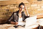 Portrait of young businesswoman making notes in cafe