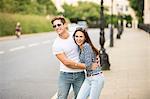 Young couple laughing on city street, London, UK