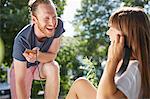 Young couple outdoors, listening to music through earphones