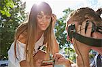 Young couple outdoors, listening to music through headphones