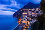 Cliff side buildings illuminated at night, Positano, Amalfi Coast, Italy