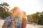 Couple holding ice cream cones hugging, Majorca, Spain