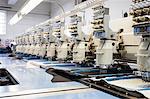 Rows of programmed embroidery machines speed stitching in clothing factory