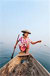 A young woman pulls in her nets at the end of the day on Indawgyi Lake, Kachin State, Myanmar (Burma), Asia