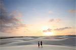 Brazil, Maranhao, Atins, Lencois Maranhenses national park, people standing in the dunes near Atins town watching the sunrise