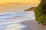 Playa Santa Teresa at sunset, Mal Pais, Costa Rica. Young girl looking at the ocean on the beach.