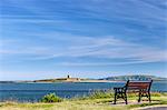 A park bench looking out towards Shenick Island , located in the Skerries Island Special Protection Area and the Martello Tower, with Lambay Island in the distance, Town parks, Skerries, Co. Dublin, Ireland.