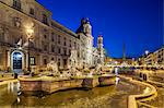 The Fontana dei Moro at the southern end of the Piazza Navona with a basin and four Tritons sculpted by Giacomo della Porta and additions by Bernini, Palazzo Pamphilini, Sant' Agnese in Agone, The Fountain of Neptune and the Fountain of the Four Rivers, Piazza Navona at twilight, Parione, Rome, Lazio, Italy.