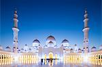 United Arab Emirates, Abu Dhabi. The courtyard and white marble exterior of Sheikh Zayed Grand Mosque. Completed in 2007 the mosque can hold over 40,000 worshippers and is made up of 82 domes and four 107m high minarets. The spectacular evening lighting varies from white to blue according to the phases of the moon.