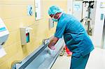 Surgeon washing their hands at washbasin in hospital