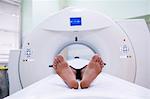 Patient lying on mri machine in scanning room at hospital