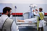 Doctor using x-ray machine to examine patient in hospital