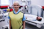 Portrait of smiling doctor standing in x-ray room at hospital