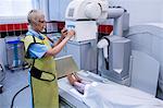 Doctor using x-ray machine to examine patient in hospital