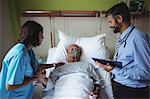 Nurse consoling senior patient with doctor in hospital