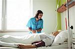 Nurse consoling senior patient in hospital