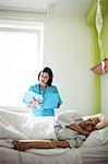 Senior patient sleeping on a bed while nurse checking report in hospital