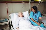 Nurse interacting with senior patient in hospital