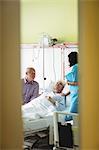 Senior couple interacting with nurse in hospital