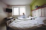 Senior woman sitting on bed in hospital