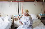 Senior woman looking at mobile phone in hospital