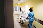 Blur image of doctor and nurse pushing a senior patient on stretcher in hospital corridor