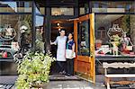 Portrait of male and female workers in bakery, standing in doorway