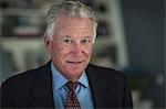 Portrait of grey haired senior businessman in office