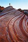 Silhouetted female tourist exploring sandstone formations at Valley of Fire State Park, Nevada, USA