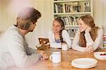 Family drinking tea and talking at dining table