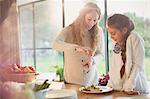 Pregnant mother serving food for daughter at dining table